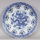 AN EARLY MING STYLE BLUE & WHITE PORCELAIN DRAGON DISH, with a barbed and flanged rim, the base
