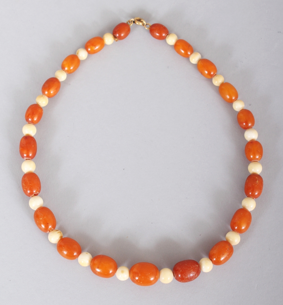 AN AMBER & IVORY NECKLACE, weighing approx. 16.5gm, composed of oval amber and spherical ivory