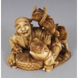 A SIGNED JAPANESE MEIJI PERIOD STAINED IVORY NETSUKE OF A SEATED MAN IN THE COMPANY OF FOUR TENGU,