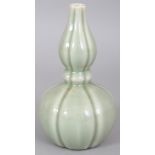 A CHINESE CELADON DOUBLE GOURD PORCELAIN VASE, of fluted hexafoil section, the base with a