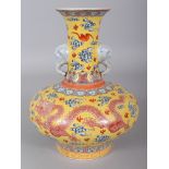 A CHINESE FAMILLE ROSE YELLOW GROUND PORCELAIN DRAGON VASE, with elephant-head handles, the base
