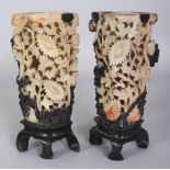 A PAIR OF 20TH CENTURY CHINESE PIERCED FLORAL SOAPSTONE VASES, on fixed soapstone stands, 7.7in