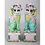 A PAIR OF 18TH CENTURY CHINESE BUDDHISTIC LION PORCELAIN JOSS STICK HOLDERS, each supported on a