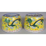 A PAIR OF EARLY 20TH CENTURY ORIENTAL YELLOW GROUND PORCELAIN DRAGON JARS, with sloping sides and