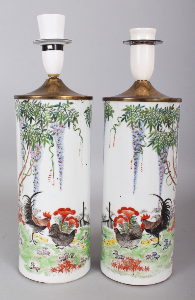 A MIRROR PAIR OF EARLY 20TH CENTURY CHINESE CYLINDRICAL PORCELAIN VASES, fitted for electricity,