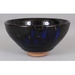 A CHINESE SONG STYLE JAIN WARE GLAZED CERAMIC TEA BOWL, the black lustrous glaze falling short of