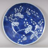 A 19TH CENTURY CHINESE BLUE & WHITE PORCELAIN PRUNUS DECORATED CIRCULAR PORCELAIN DISH, 11.5in