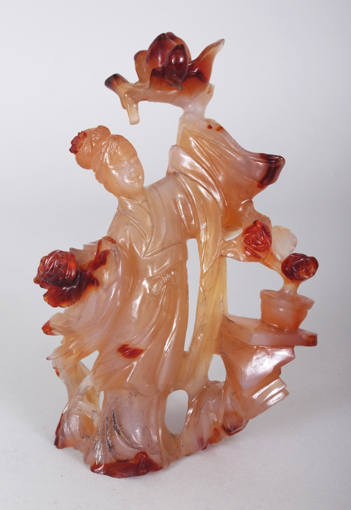 A CHINESE AGATE CARVING OF A STANDING LADY, bearing aloft a bowl of peach, 6in high.