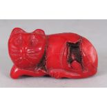 A MINIATURE RED CORAL CARVING OF A CAT, 1.3in long & 0.5in high.