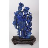 A CHINESE LAPIS CARVING OF GUANYIN, together with a wire-inlaid fixed wood stand, 5.25in high