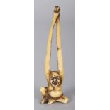 A JAPANESE MEIJI PERIOD STAINED IVORY NETSUKE OF TENAGA, his long arms stretched out above his