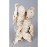 A JAPANESE MEIJI PERIOD IVORY OKIMONO OF A STREET PERFORMER, holding a hand drum and in the
