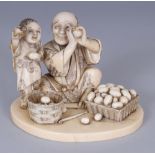 A GOOD QUALITY SIGNED JAPANESE MEIJI PERIOD IVORY OKIMONO OF A FATHER & SON WITH BASKETS OF EGGS,