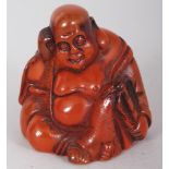 A SMALL AMBER STYLE NETSUKE OF BUDDHA, the base with an engraved mark, 1.8in high.