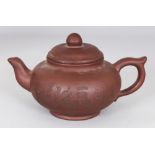 AN EARLY/MID 20TH CENTURY YIXING POTTERY TEAPOT & COVER, the sides incised with calligraphy and