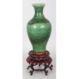 A GOOD 18TH CENTURY CHINESE GREEN GLAZED BALUSTER PORCELAIN VASE, together with a wood stand, the