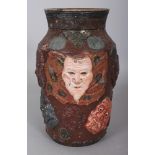 AN UNUSUAL JAPANESE MEIJI PERIOD POTTERY VASE, moulded with a variety of Noh masks, 9.25in high.