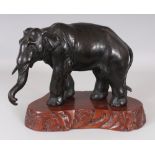 A SIGNED JAPANESE MEIJI PERIOD BRONZE MODEL OF A STANDING ELEPHANT, together with a wood stand,