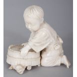 A FINE QUALITY SIGNED JAPANESE MEIJI PERIOD IVORY OKIMONO OF A KNEELING BOY, attempting to trap a