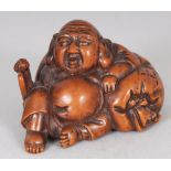 A JAPANESE MEIJI PERIOD CARVED WOOD NETSUKE OF HOTEI, reclining on his bag, 1.8in wide & 1.25in