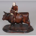 AN EARLY 20TH CENTURY JAPANESE IVORY & WOOD GROUP OF A MAN RIDING A BULL, the base with an