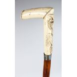 A WALKING CANE with silver band and carved ivory handle with fruiting vines.