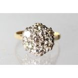 AN 18CT GOLD SEVEN STONE DIAMOND CLUSTER RING.