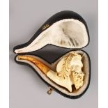 A GOOD MEERSCHAUM CARVED PIPE, head with cap and feathers in a leather case. 5.5ins long.