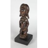 A CARVED TRIBAL FEMALE FIGURE on a later stand. 9ins high.