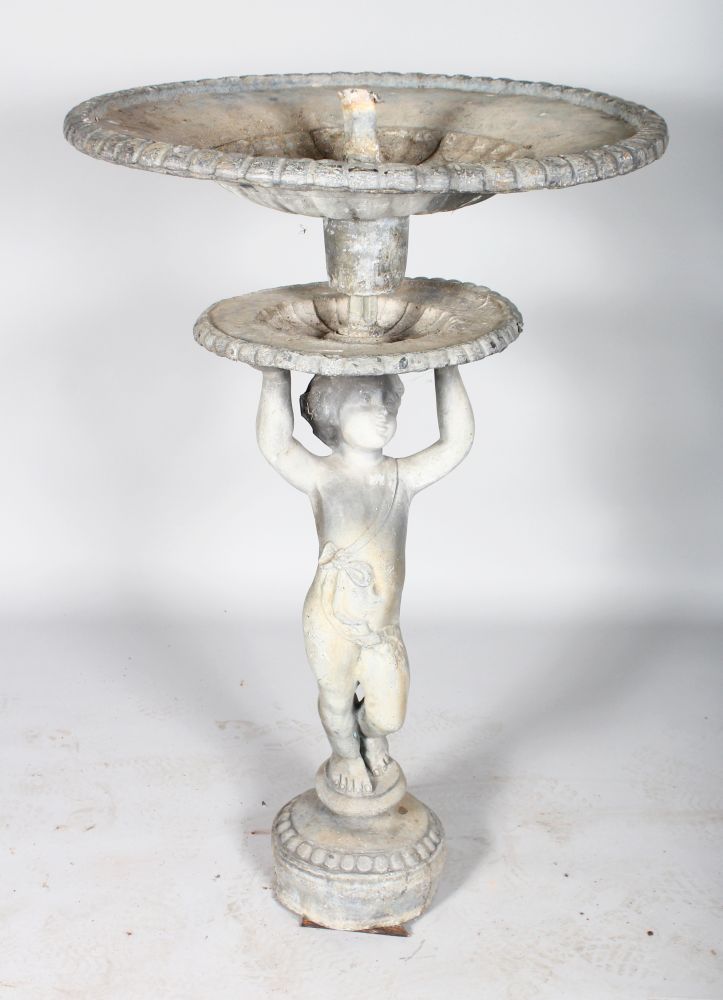 AN 18TH CENTURY LEAD FOUNTAIN, a cupid holding two circular dishes. 2ft high.