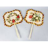 A GOOD PAIR OF VICTORIAN IVORY AND SILK FANS with needlework flowers in relief.