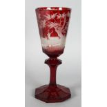 A LARGE RUBY BOHEMIAN GOBLET, the bowl etched with deer in a landscape. 10.5ins high.