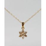 A 9CT YELLOW GOLD SEVEN DIAMOND DAISY PENDANT AND CHAIN.