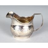 A GEORGE III MILK JUG with engraved decoration. London 1790. Maker: I. M.