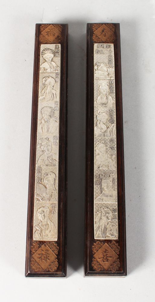 A PAIR OF CHINESE ROSEWOOD AND METAL SCROLL WEIGHTS, each depicting women, possibly of the court.