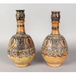 A GOOD PAIR OF ISLAMIC POTTERY BULBOUS VASES with a pattern in blue. 13ins high.