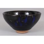 A CHINESE SONG STYLE JAIN WARE GLAZED CERAMIC TEA BOWL, the black lustrous glaze falling short of