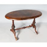 A VICTORIAN OVAL FIGURED WALNUT STRETCHER TABLE, with figured walnut top, carved end supports and