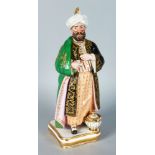 A PARIS PORCELAIN FIGURE OF A STANDING TURK wearing a gilt decorated coat and gown. 13ins high.