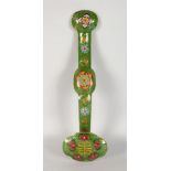 A CHINESE CLOISONNE RUYI SCEPTRE, on a green ground with flower motifs. 1ft 4ins long.
