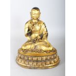 A GILT BRONZE SEATED FIGURE OF A BUDDHA. 10ins high.