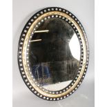 A PERIOD IRISH OVAL WITCHES MIRROR. 28ins x 22ins.