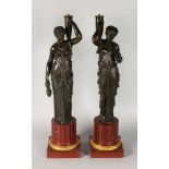 A SUPERB PAIR OF LOUIS XVI BRONZE FIGURES OF CLASSICAL LADIES carrying urns as lamps, on marble