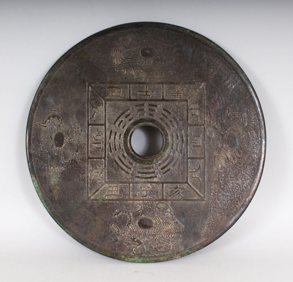 A DARK GREEN JADE BI DISC, the disc is carved on both sides with characters and serpents. 12ins