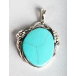 A SILVER AND TURQUOISE PENDANT.