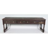 A GOOD LONG EARLY 18TH CENTURY OAK DRESSER BASE, with double plank top, the frieze with three