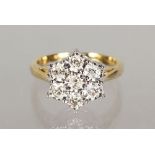A 9CT GOLD SEVEN DIAMOND DAISY CLUSTER RING.