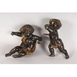 A PAIR OF BRONZE PUTTI, dark brown patina (2). 9.5ins high.