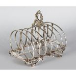 A GEORGE III SIX DIVISION TOAST RACK with pierced shell feet. London 1800.