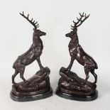 AFTER J. MOIGNIEZ A PAIR OF BRONZE STAGS standing on rocks. Signed. 18ins high.